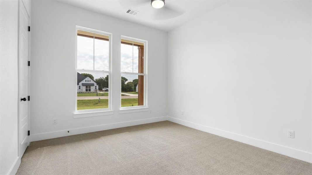 Carpeted spare room featuring ceiling fan