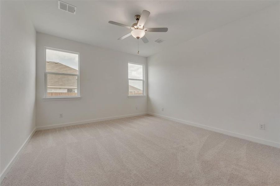 Carpeted empty room featuring ceiling fan