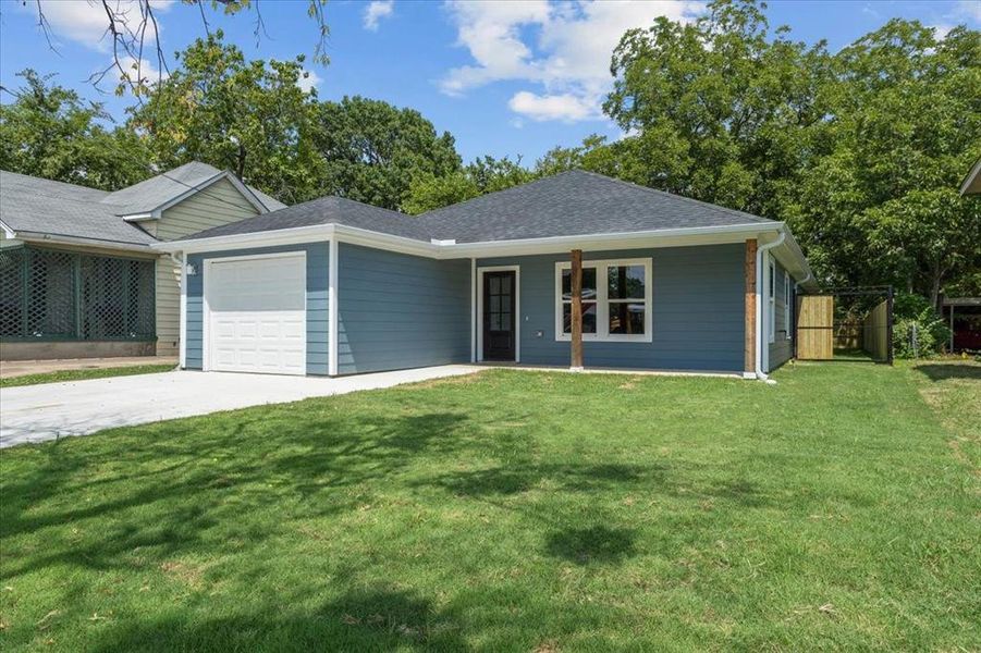 Ranch-style house featuring a garage and a front yard