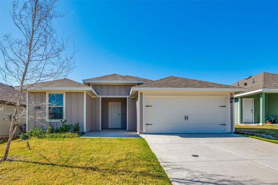 Ranch-style home with a front lawn and a garage