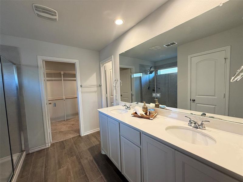 Bathroom featuring hardwood / wood-style flooring, vanity, and an enclosed shower