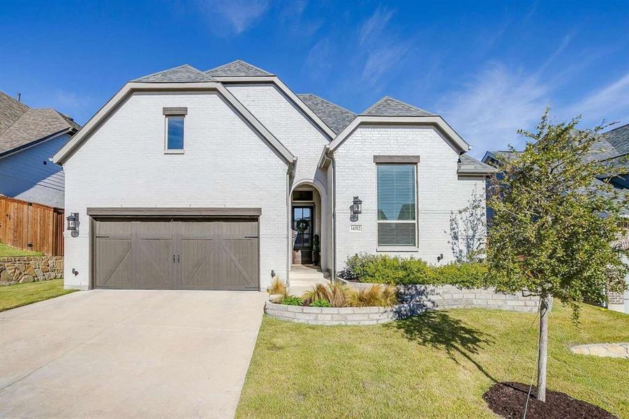 View of front of home featuring a front lawn and a garage