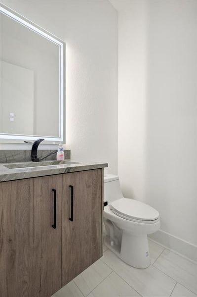 Bathroom featuring vanity, toilet, and tile patterned floors