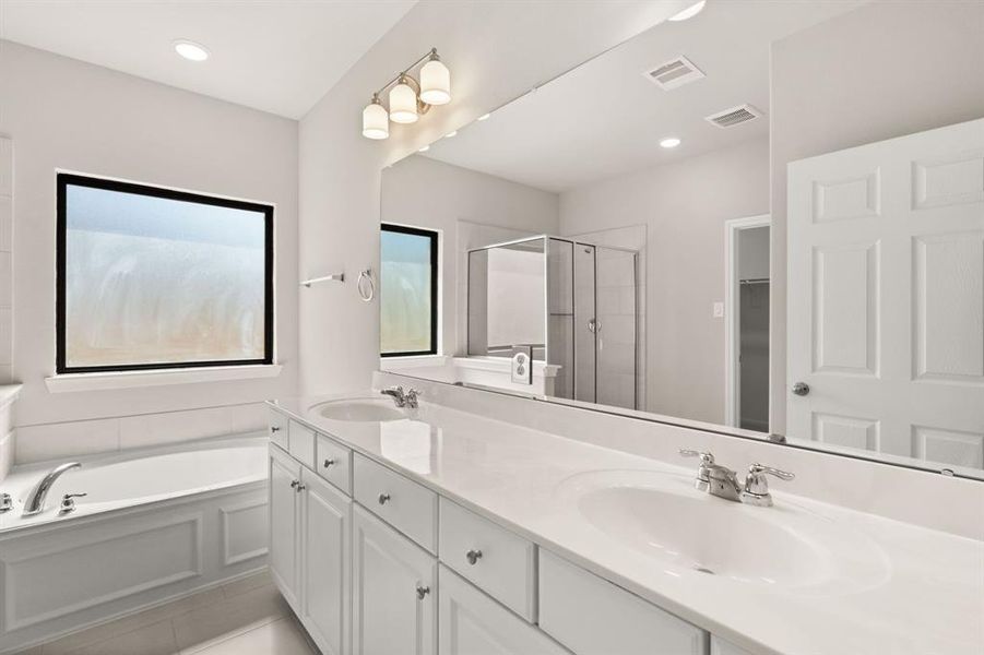 The en-suite bathroom offers a spa-like atmosphere with its elegant design, high end finishes, and tasteful lighting, creating a retreat within your own home.