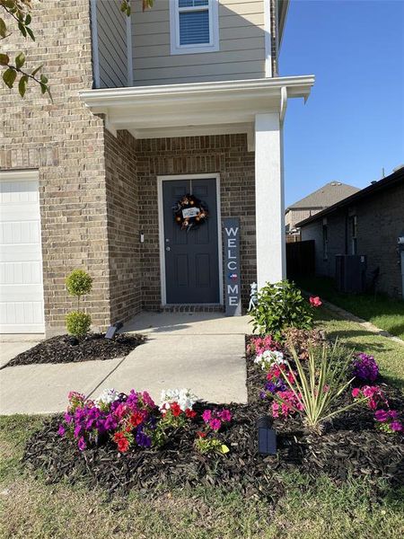 View of exterior entry featuring covered porch and a garage