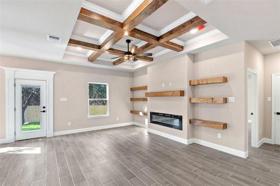 Unfurnished living room with wood-type flooring, ceiling fan, coffered ceiling, and beam ceiling