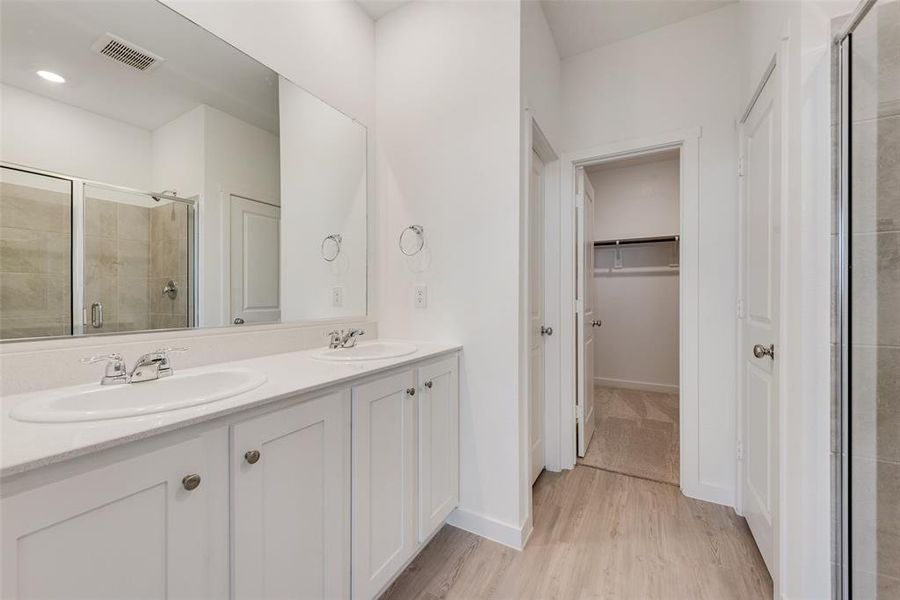 Bathroom featuring vanity, a shower with shower door, and hardwood / wood-style flooring