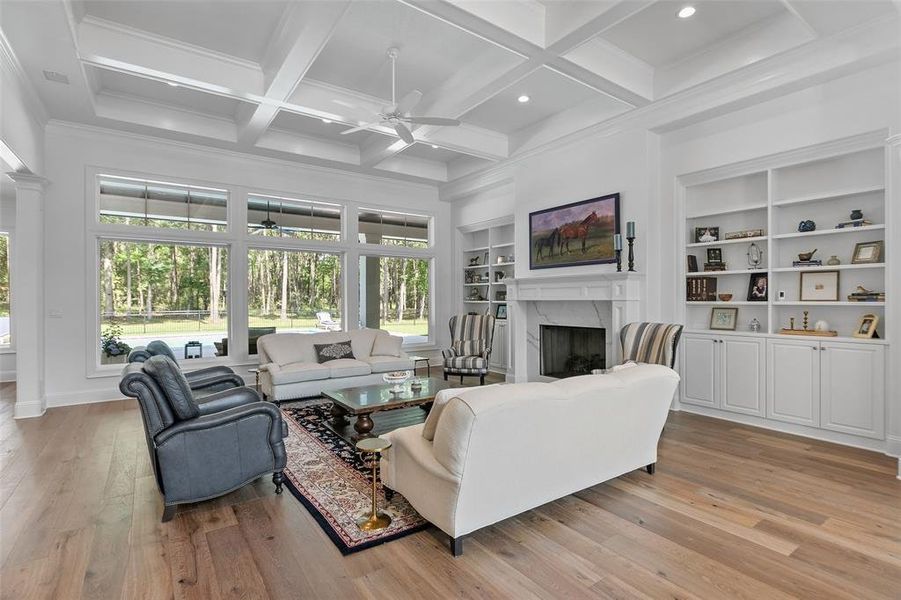 The family room offers an exceptional coffered ceiling, crown molding, double base boards, and the fireplace is flanked by built-in display shelves and storage on either side of the fireplace. Wall of windows are complete with fabulous decorative wood casings.