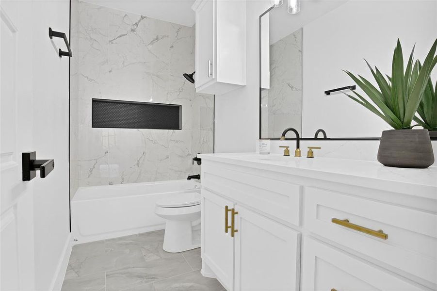 Full bathroom featuring toilet, tiled shower / bath combo, and vanity