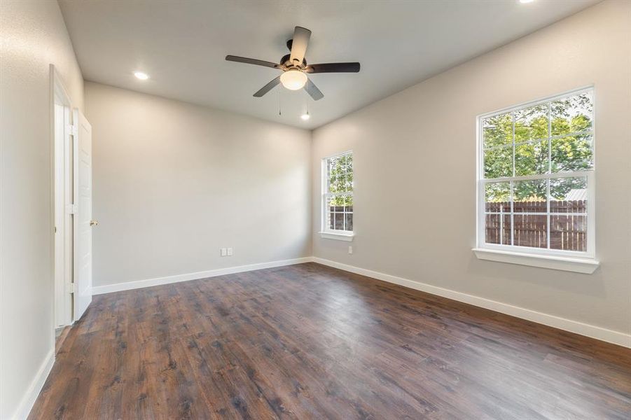 Unfurnished room featuring ceiling fan and dark hardwood / wood-style floors