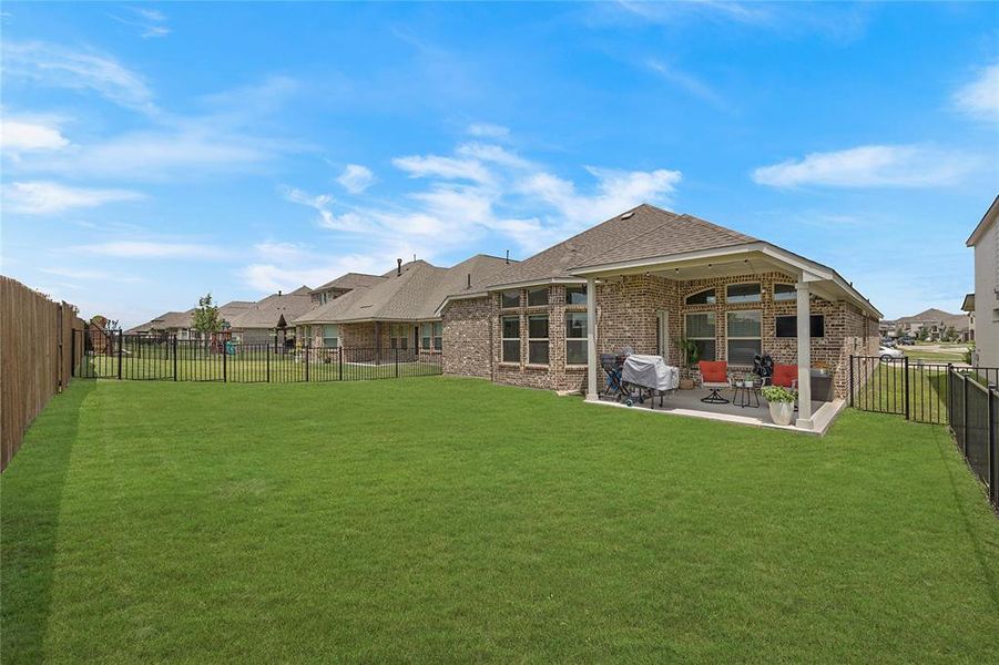 Rear view of property with a patio and a lawn