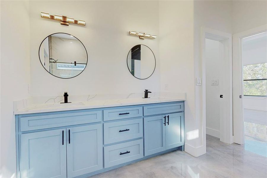 Bathroom featuring tile patterned floors and dual bowl vanity