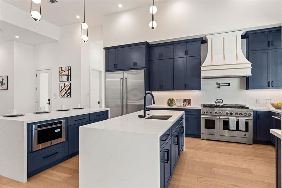 Waterfall edge, QUARTZ countertops complete each of the TWO islands and compliment the built in storage surrounding the kitchen as well as the stainless steel appliances and pendant lighting.