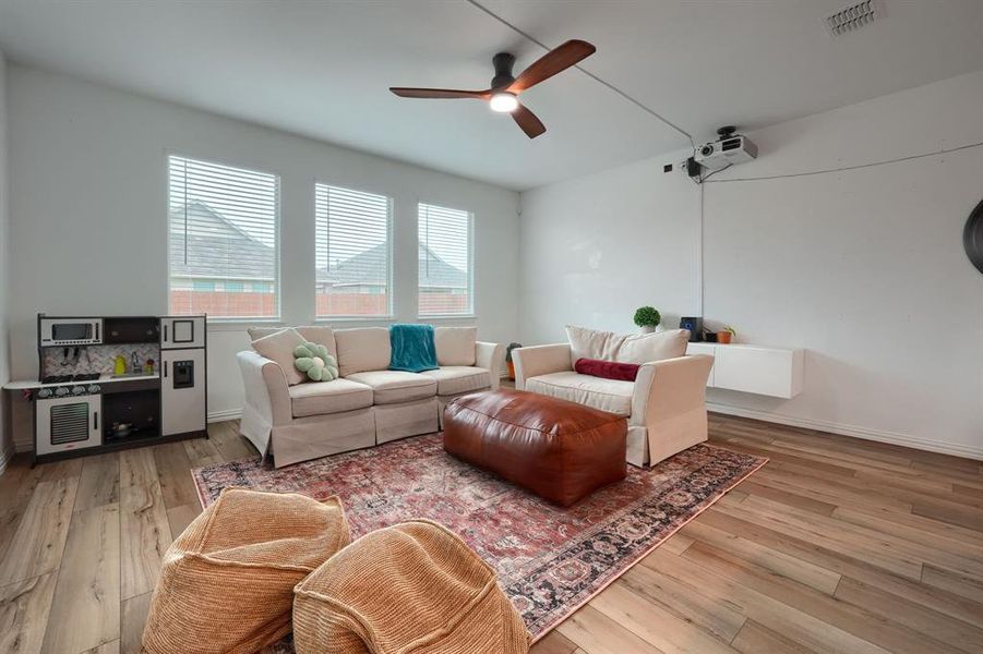 Living room with light wood-type flooring and ceiling fan