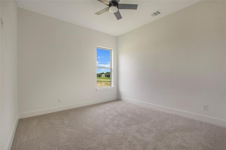 Carpeted empty room with ceiling fan