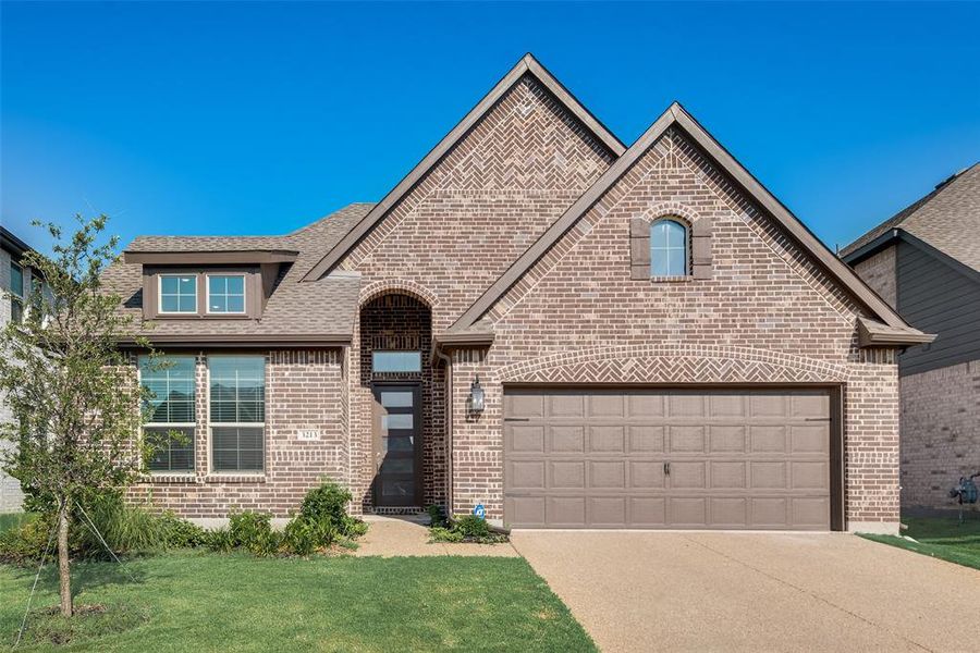 View of front facade with a garage and a front lawn