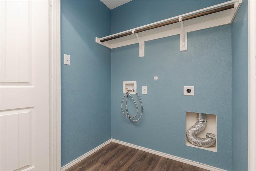 Clothes washing area with hookup for a washing machine, dark hardwood / wood-style floors, and hookup for an electric dryer