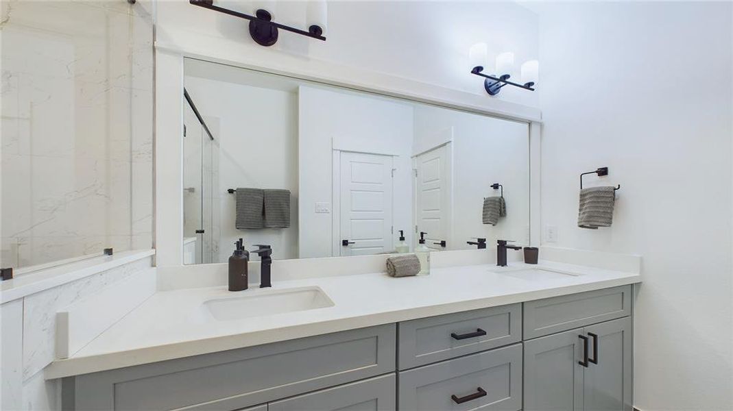 A beautiful primary bathroom featuring a Quartz double sink vanity top, complemented by soft-close drawers and doors.