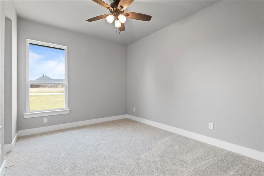 Carpeted spare room with ceiling fan