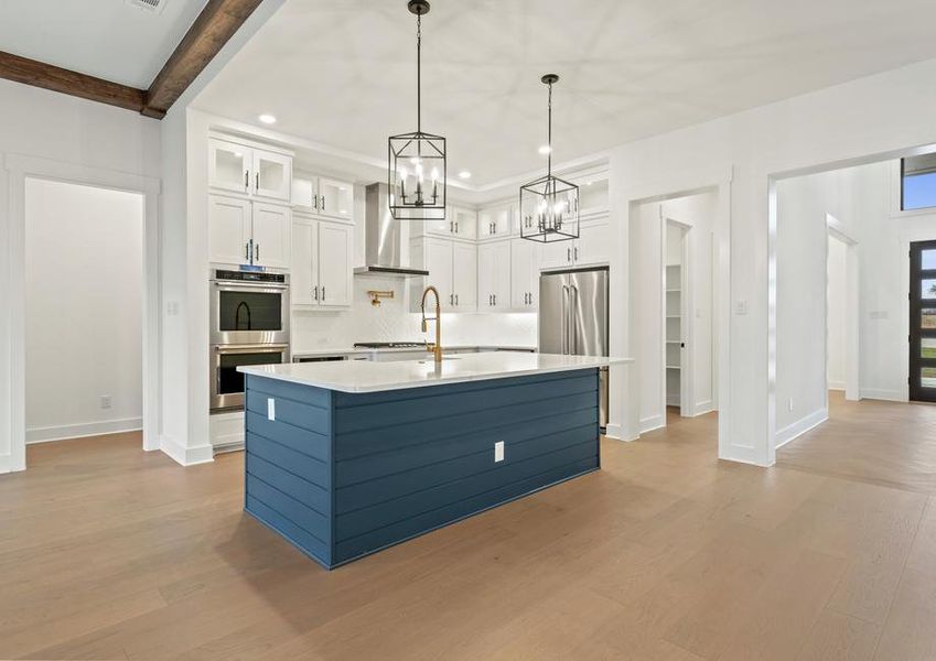 The kitchen has a beautiful blue island with quartz countertops.