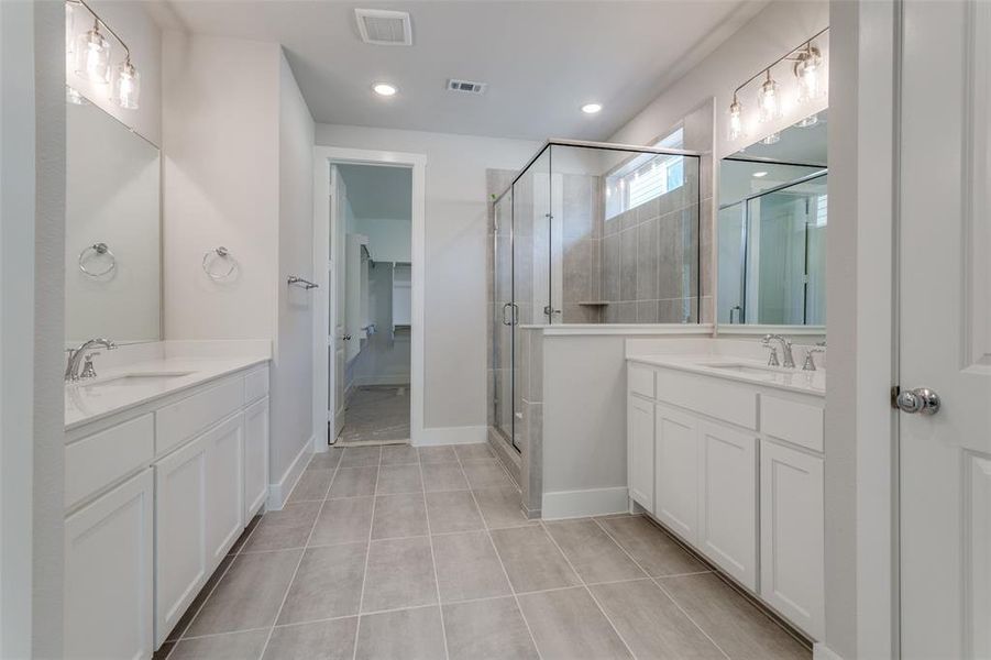 Bathroom featuring walk in shower, oversized vanity, and tile floors