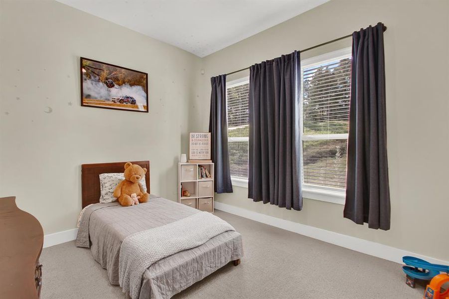 A cozy, secondary well-lit bedroom perfect for a child or as a guest room.