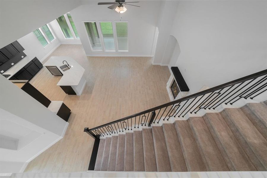 Stairs with a high ceiling, hardwood / wood-style floors, ceiling fan, and sink