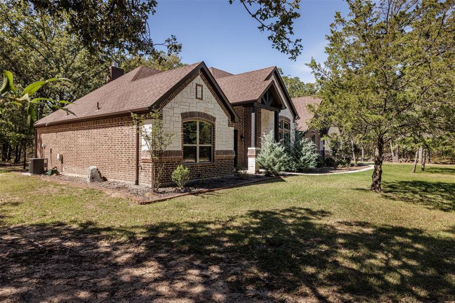 View of front facade with a front yard and central AC