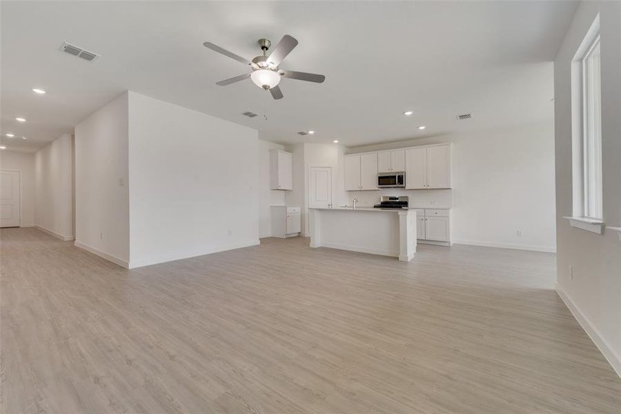 Unfurnished living room with light hardwood / wood-style flooring and ceiling fan