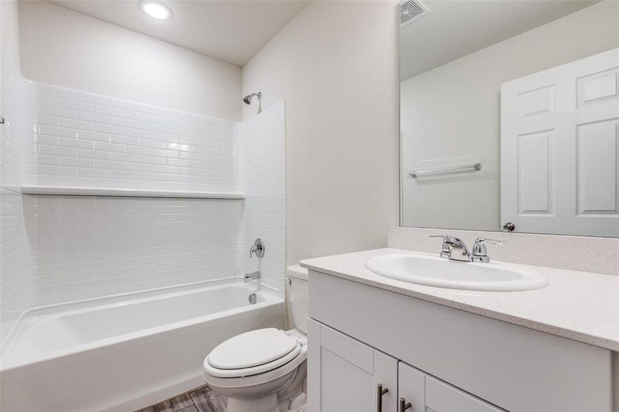 Full bathroom with washtub / shower combination, vanity, and toilet