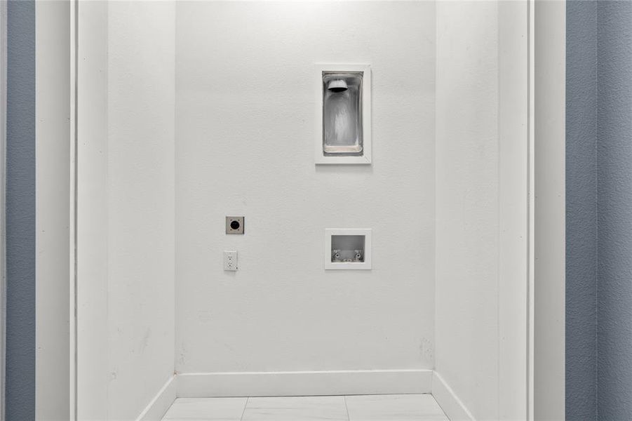 Clothes washing area featuring light tile patterned flooring, washer hookup, and hookup for an electric dryer