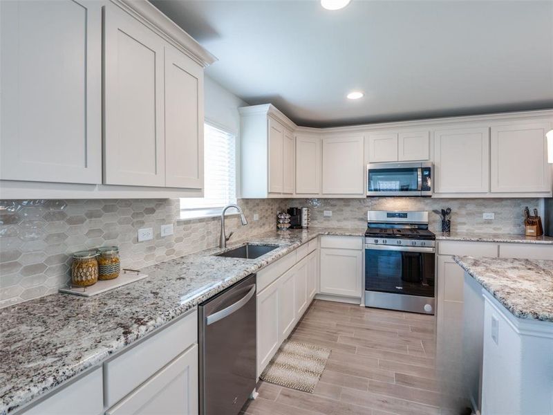 Stainless steel appliances and window at sink to brighten room