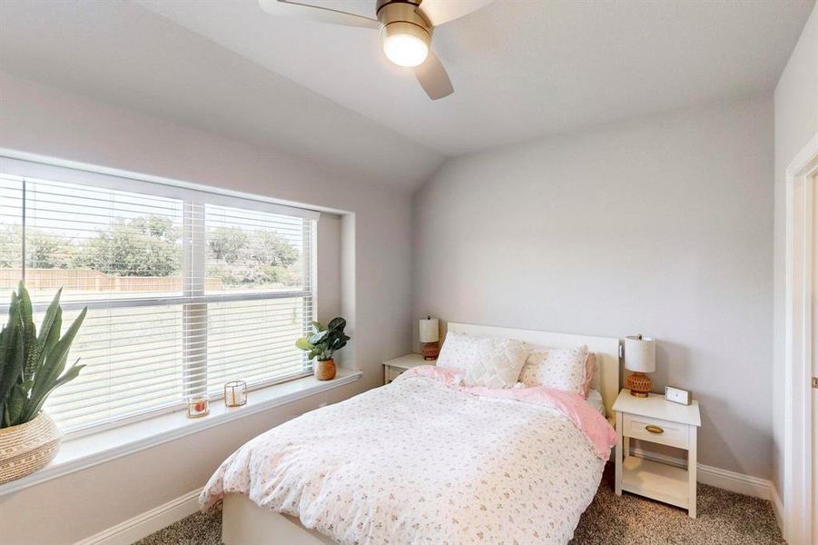 Bedroom with carpet floors, lofted ceiling, and ceiling fan