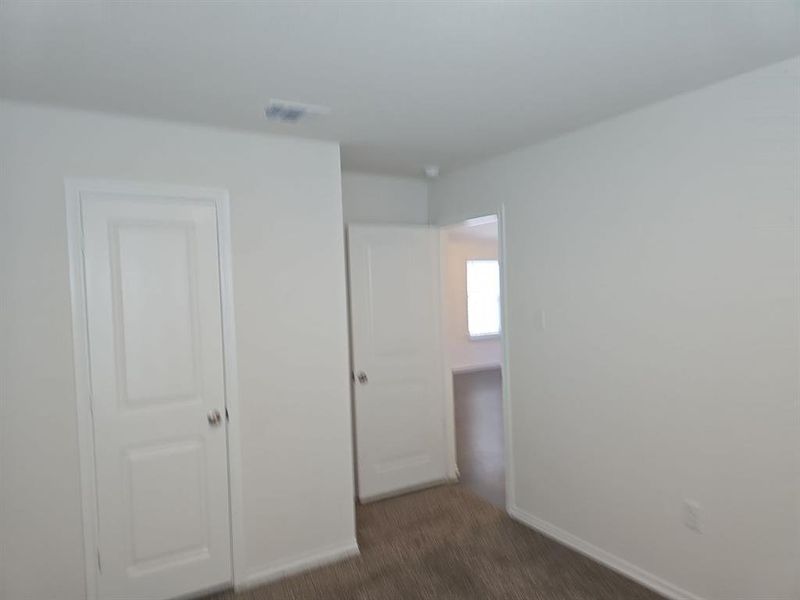 Unfurnished bedroom featuring dark colored carpet