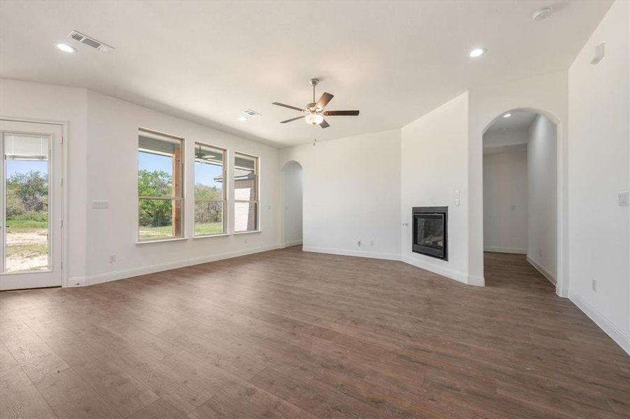 Unfurnished living room with ceiling fan and dark hardwood / wood-style flooring