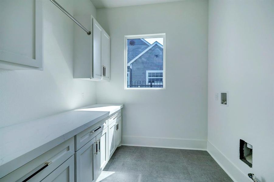Substantial space in the utility room includes counter, soft-close storage, and built-in hanging rod