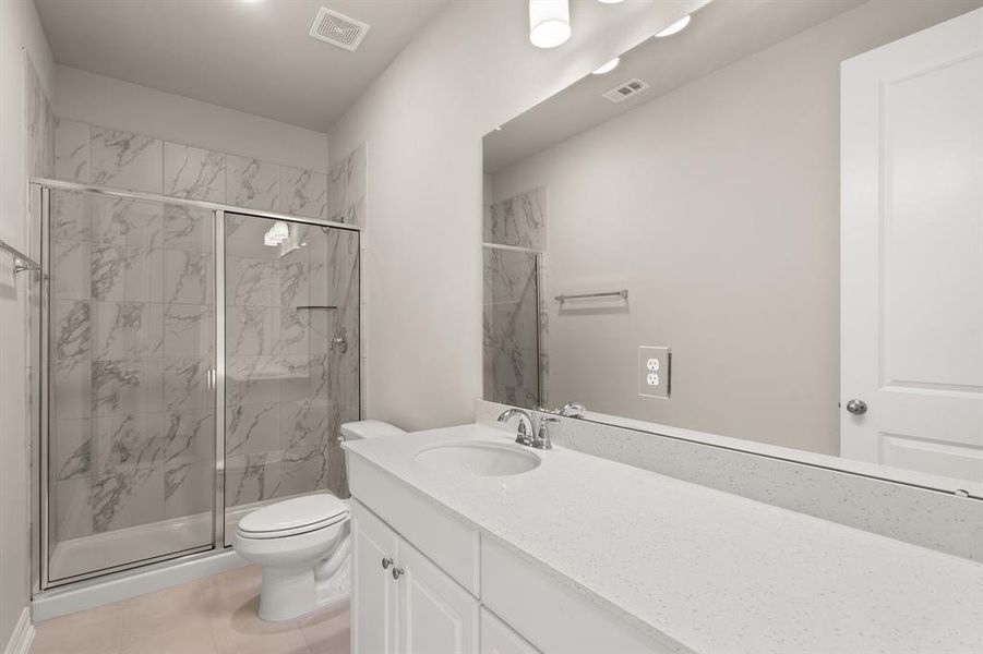 The secondary bath features tile flooring, white cabinetry and light countertops and a shower/tub combo. Perfect for accommodating any visiting family and friends.