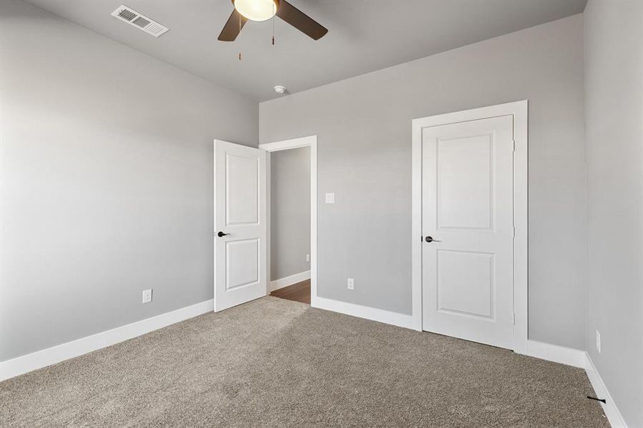 Unfurnished bedroom with carpet floors and ceiling fan