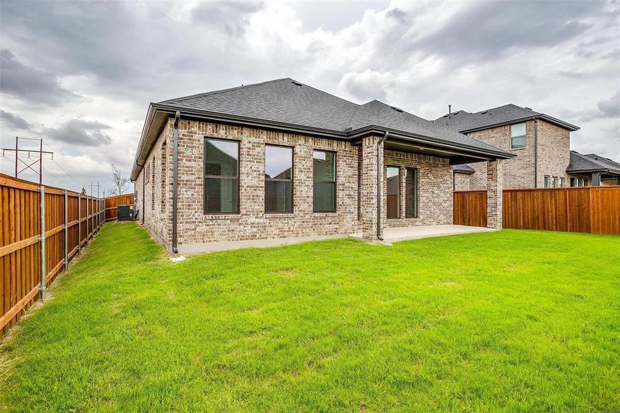 Back of house with a patio, a lawn, and central air condition unit