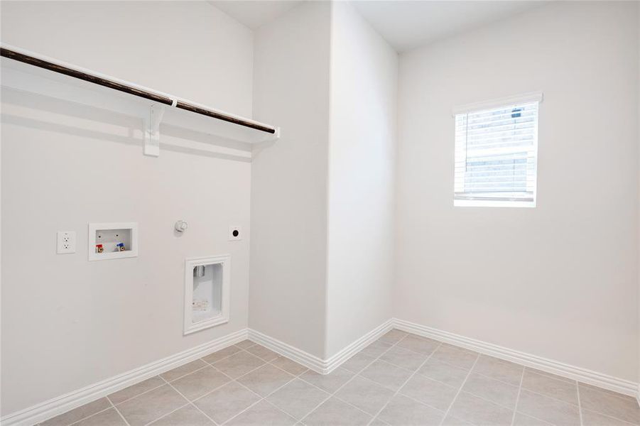 Laundry area featuring hookup for an electric dryer, gas dryer hookup, washer hookup, and light tile patterned floors