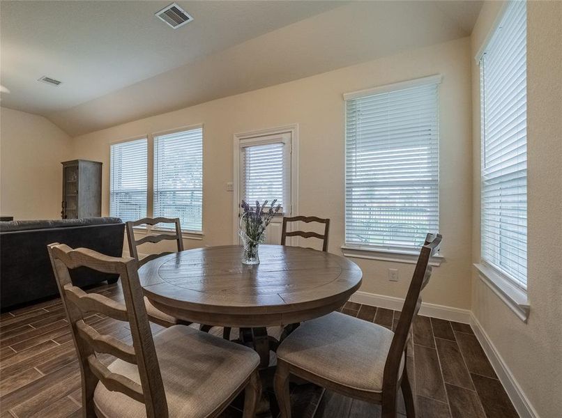 here you can see how the dining area, and family room flow very smoothly, several oversized windows for natural light and the back door leading to the covered patio