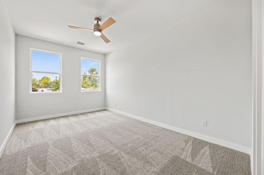 Carpeted spare room with ceiling fan