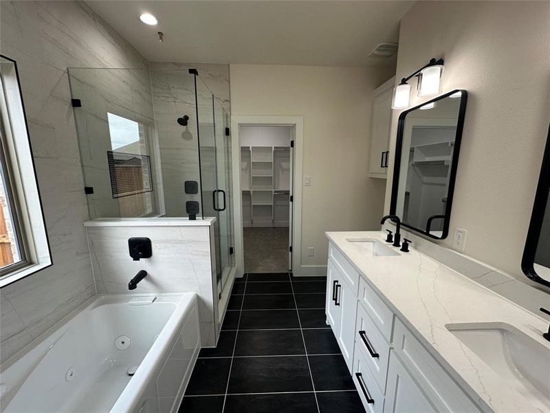 Bathroom with dual vanity, shower with separate bathtub, and tile patterned flooring