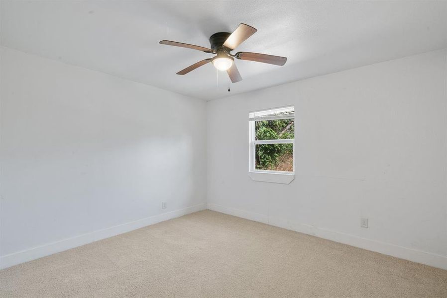 Spare room featuring ceiling fan and light colored carpet