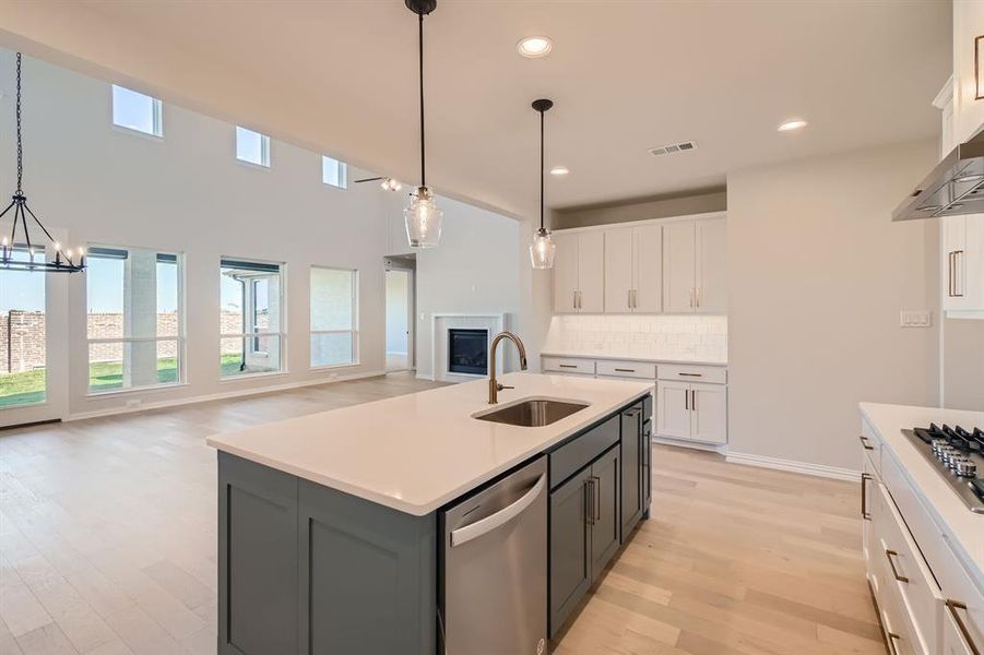 Kitchen with a center island with sink, white cabinetry, sink, pendant lighting, and stainless steel appliances