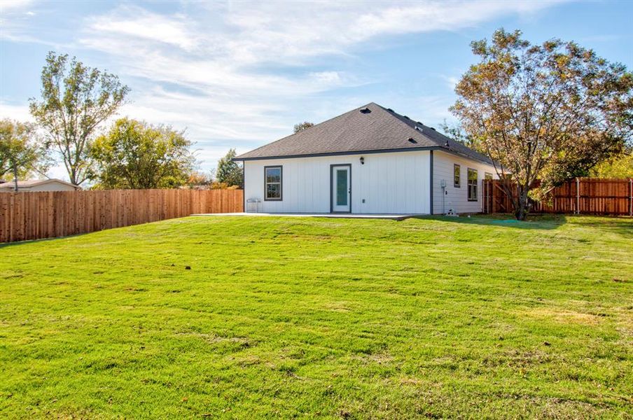 Rear view of property with a patio and a yard