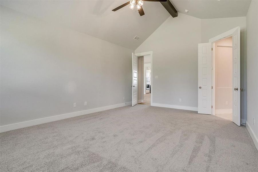 Unfurnished bedroom with carpet flooring, beamed ceiling, high vaulted ceiling, and ceiling fan