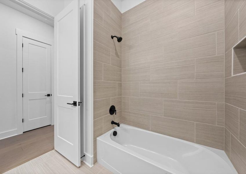 The secondary bathroom has a large, tiled  shower-tub combo.