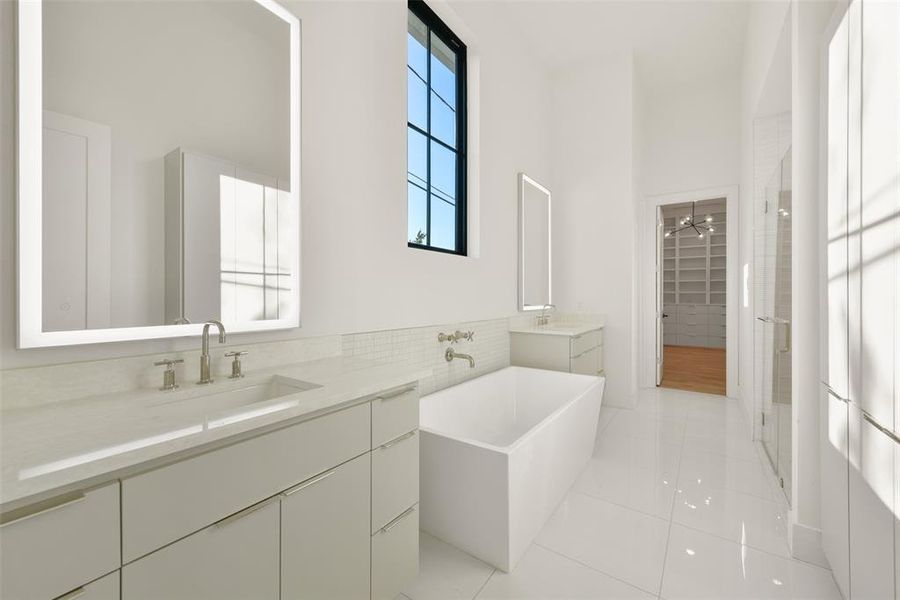 The primary bath also includes 14 foot tall ceilings, large vessel tub custom vanities with lighted mirrors a large walk-in shower and a wall of built-in storage cabinets for linens and more.