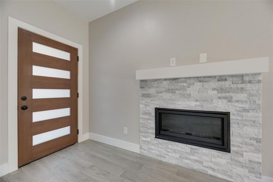 Foyer entrance featuring light ceramic tile hardwood / wood-style floors and a fireplace